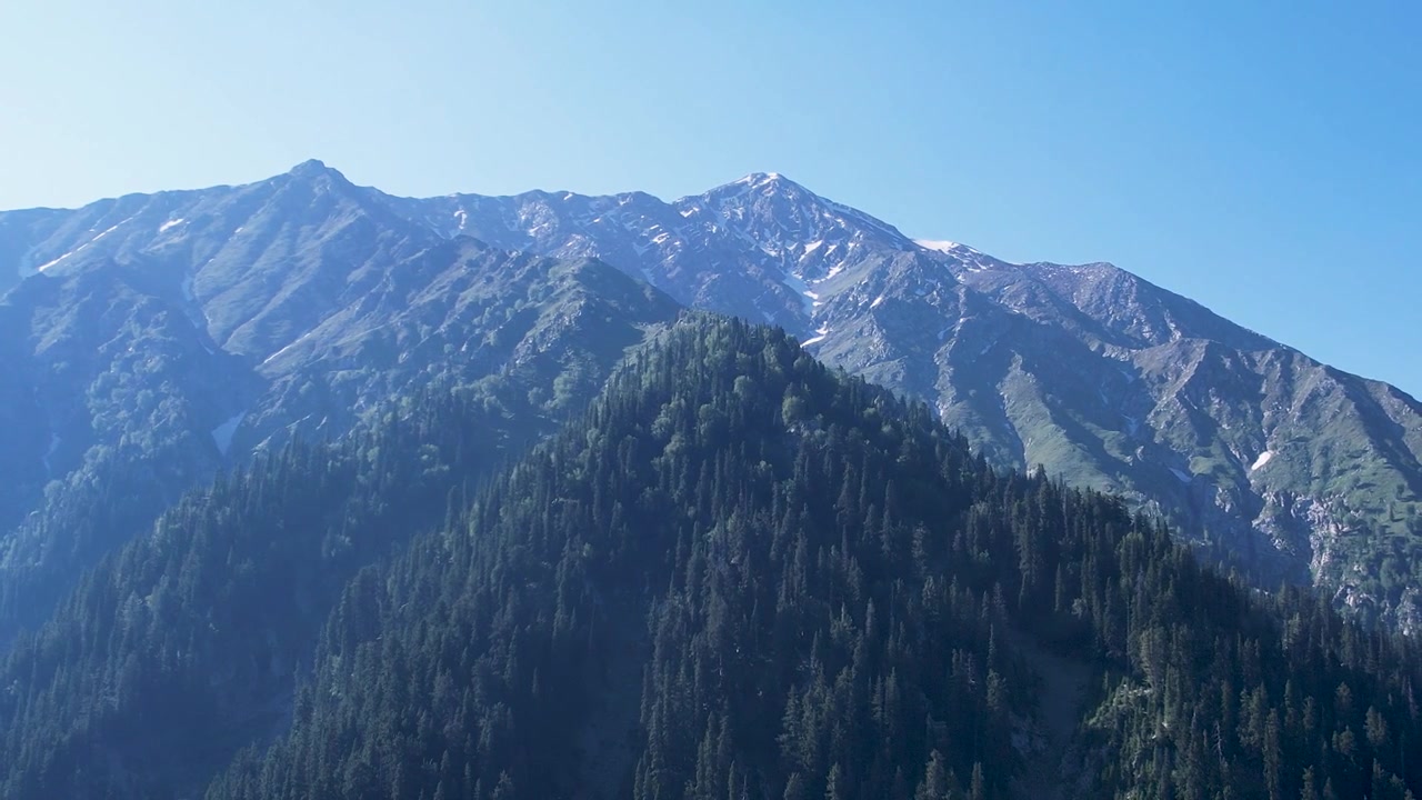 Sneklædte bjerge rejser sig over tætte nåleskove i Kumrat-dalen, Khyber Pakhtunkhwa, Pakistan