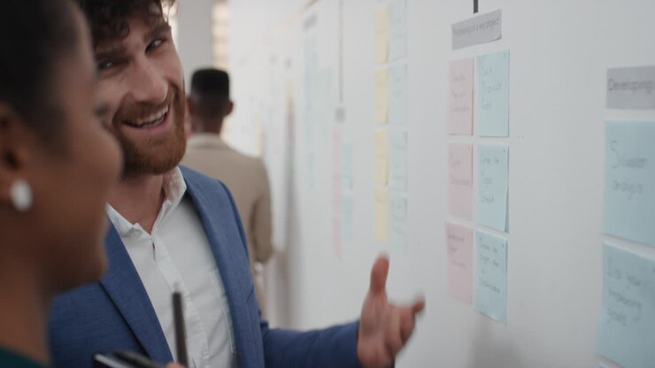 corporate business people meeting using sticky notes brainstorming attractive businessman sharing problem solving strategy on whiteboard working on solution for project deadline