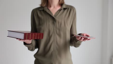 person balancing a book and a smartphone