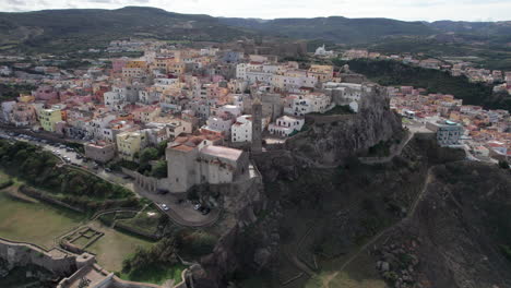 ciudad de castelsardo, cerdeña: vista aérea en un círculo sobre la colorida ciudad y su histórica torre en la isla de cerdeña