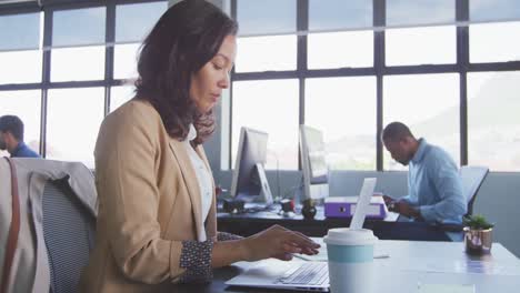 mujer de negocios bebiendo café en una oficina moderna