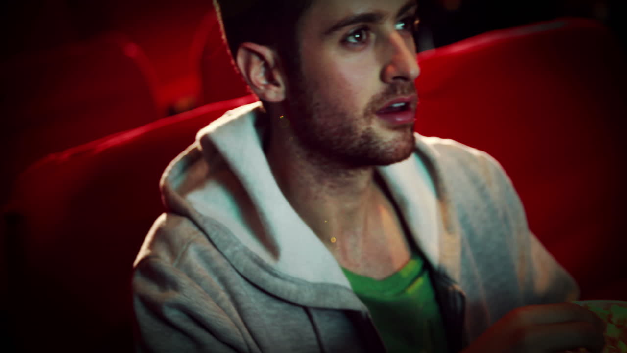 영화 를 보고 있는 매료 된 젊은 남자