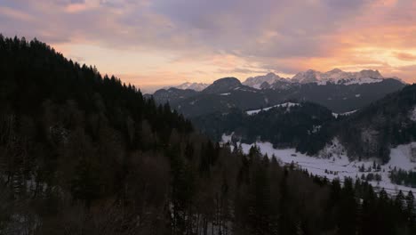 mountain valley sunset in snowy landscape with snow, sunlight and forest