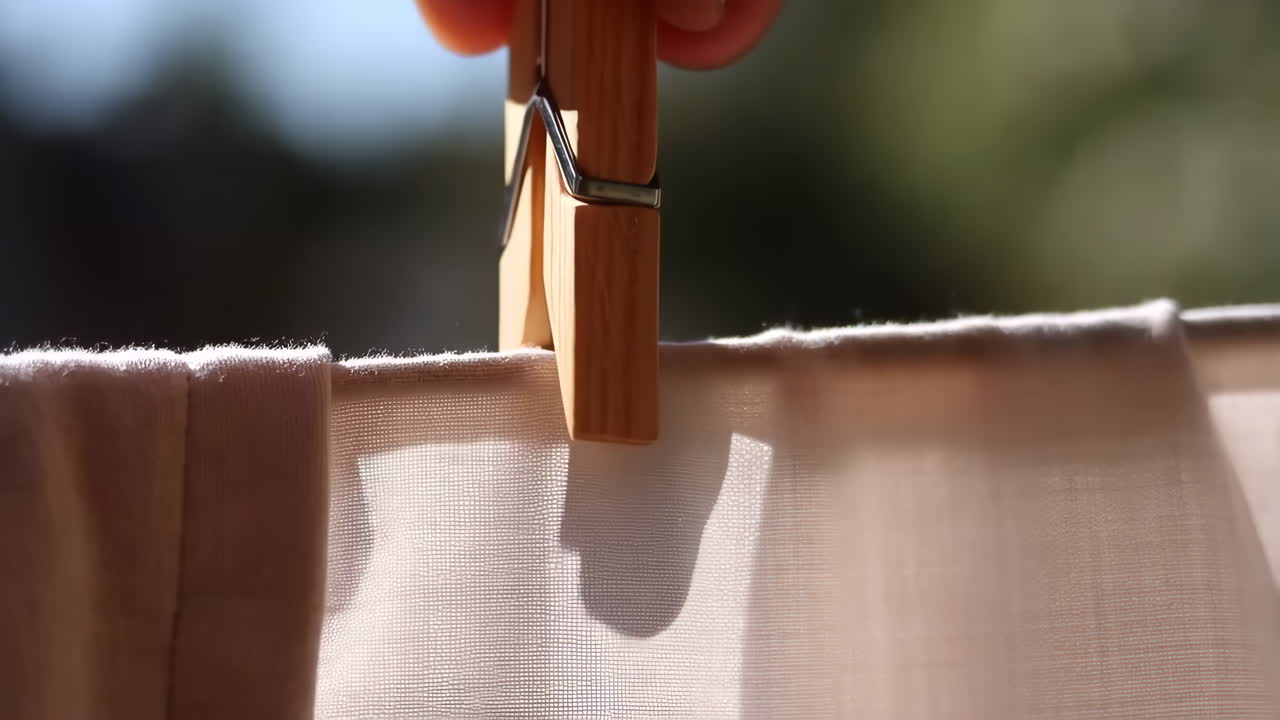 Hand attaching or removing a clothespin from fabric