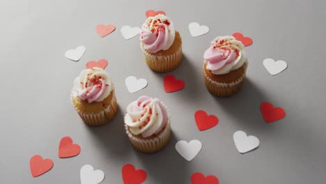 paper hearts and cupcakes on green background at valentine's day