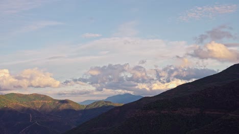 mountain silhouette with clouds passing by during sunset