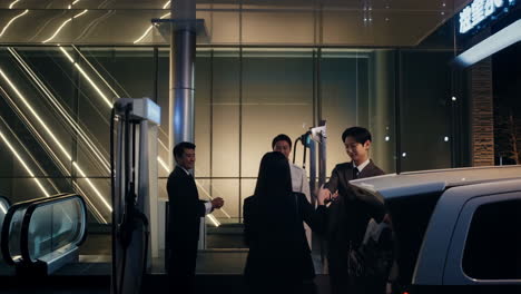 Nighttime Scene with Business Professionals and EV Charging Station
