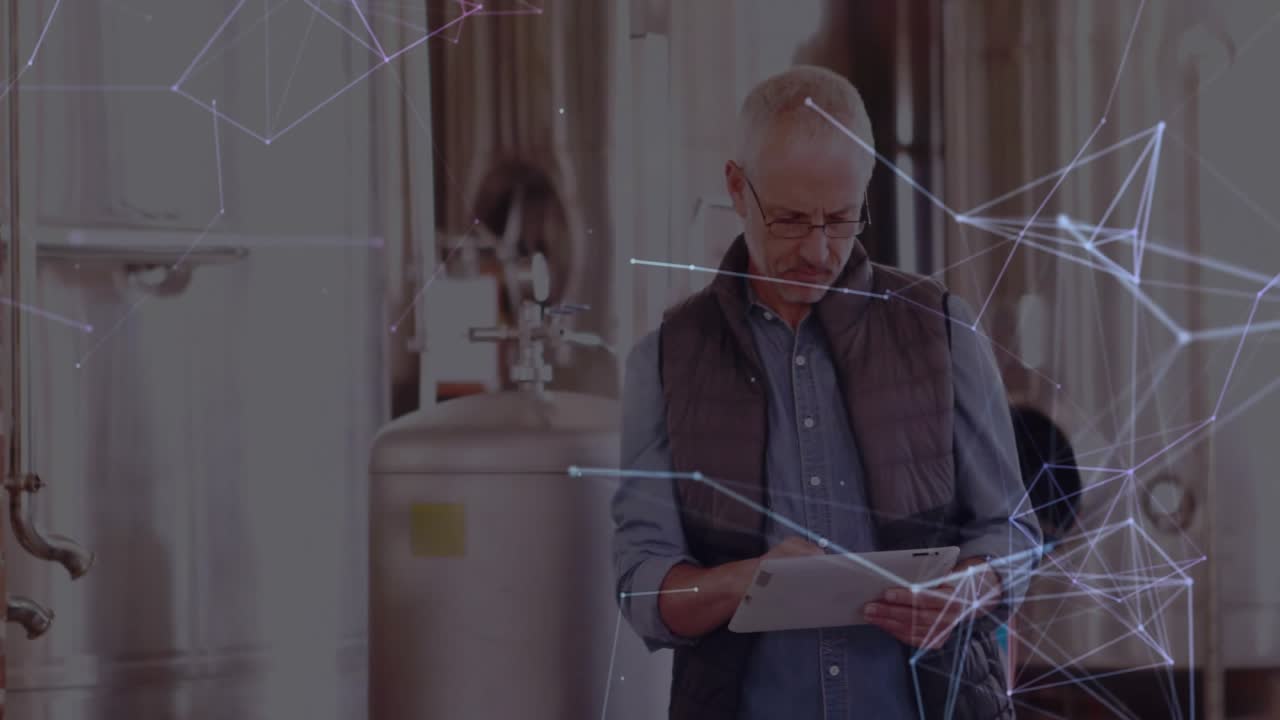Brew master checking tablet inside brewery, overlaying network lines mapping smart manufacturing