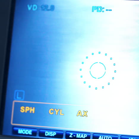 refractometer machine. patient testing eyes in clinic. screen showing progress of eye examination. close-up.