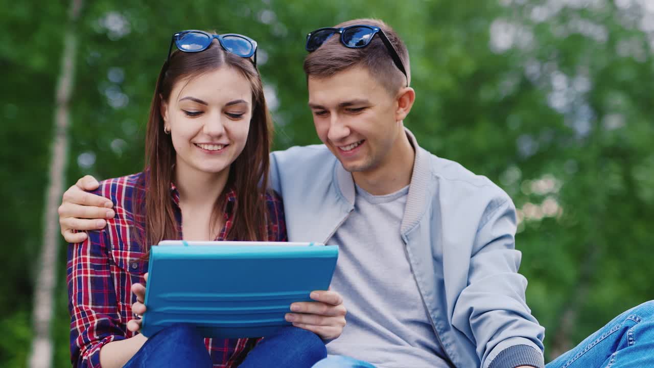 Young Girl And A Guy Used A Tablet In The Park Boy Embraces Girl Hd Video