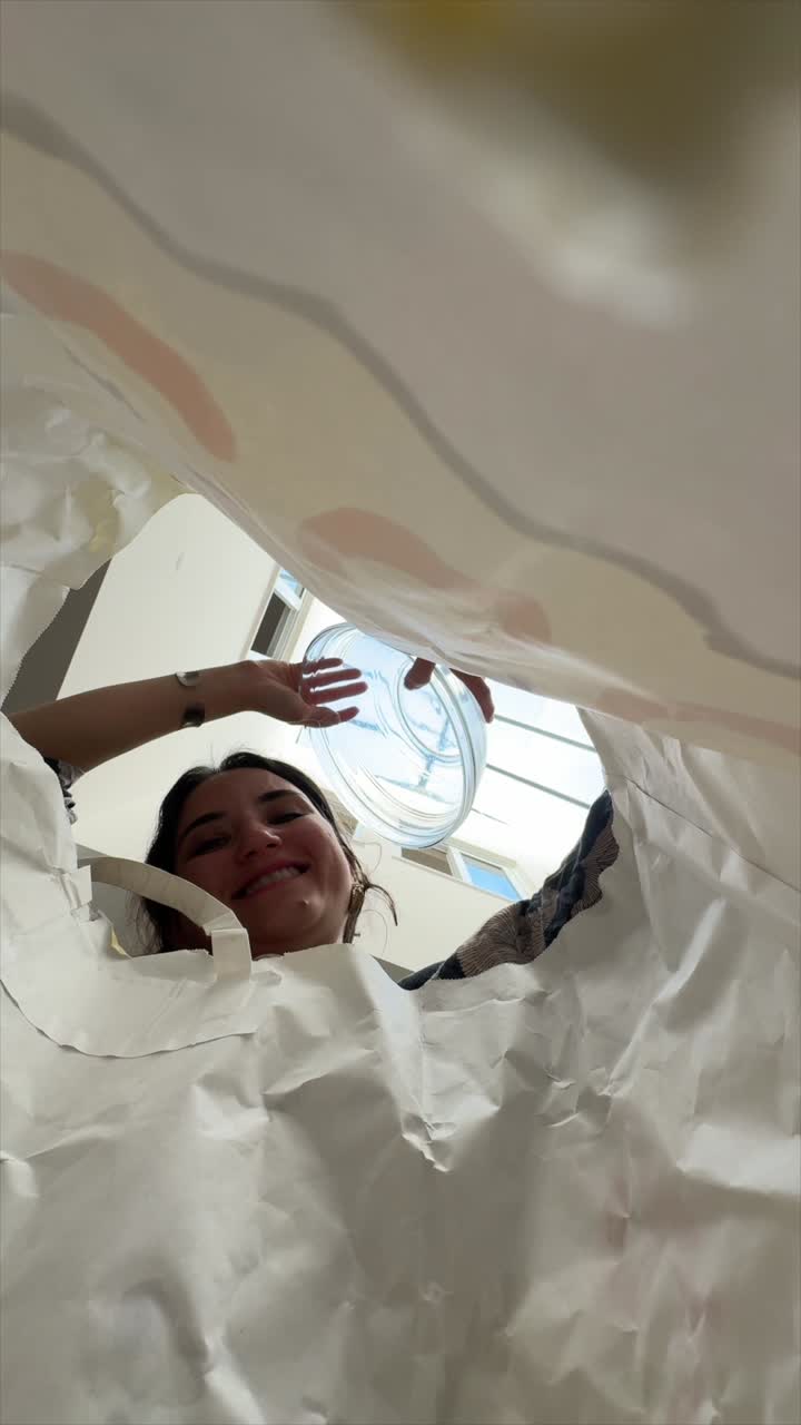 Woman looking up inside a large paper bag