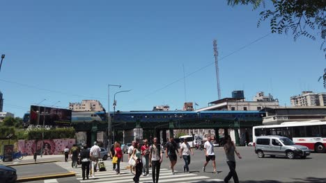 pedestrians cross buenos aires city avenue at palermo with railway cross background in summer daylight