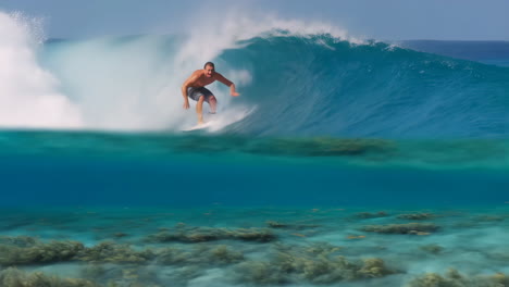 surfer riding a powerful wave with a clear underwater view of coral reef