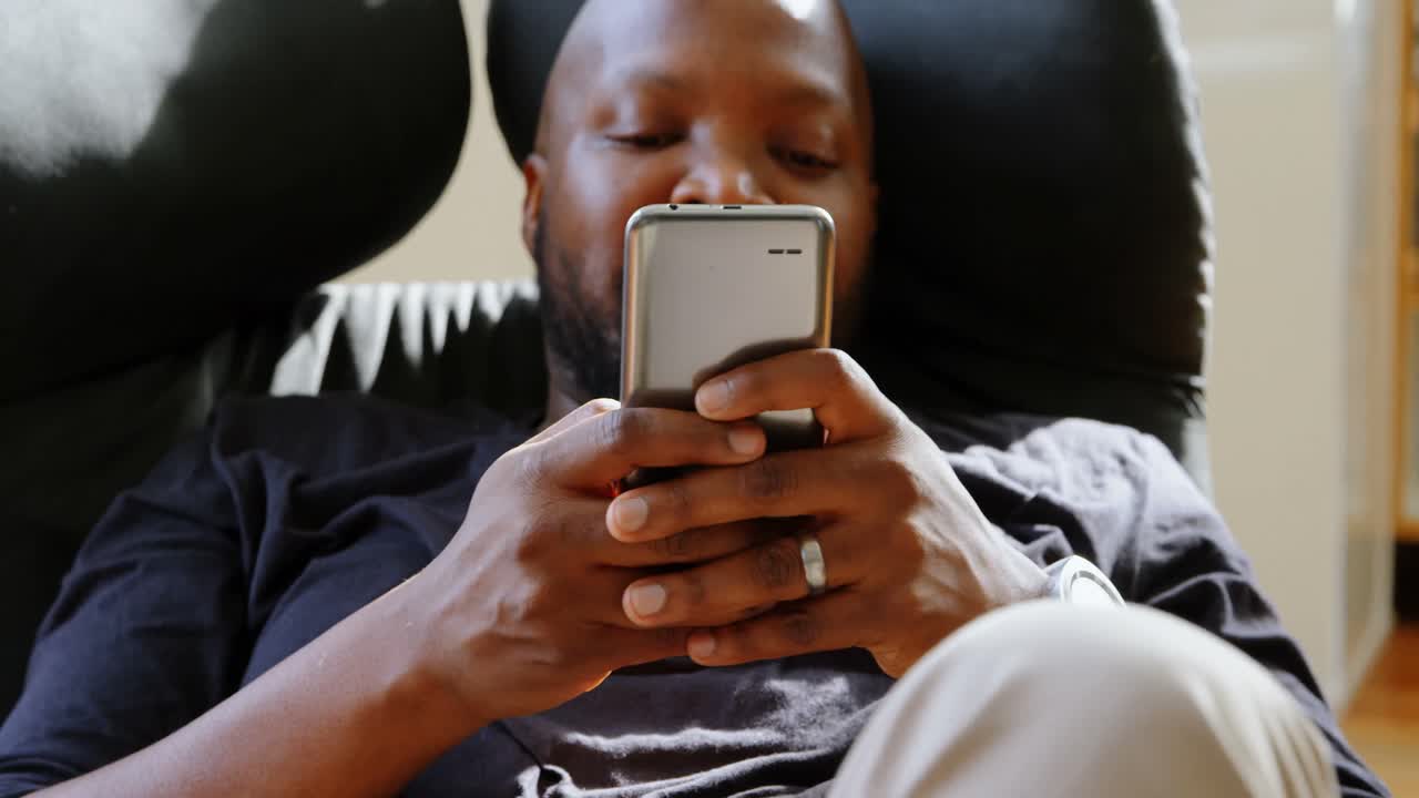 Man using mobile phone in a comfortable home 4k