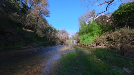 drone fpv vuela bajo sobre el río, asciende cascada y se eleva por encima de las aves rapaces