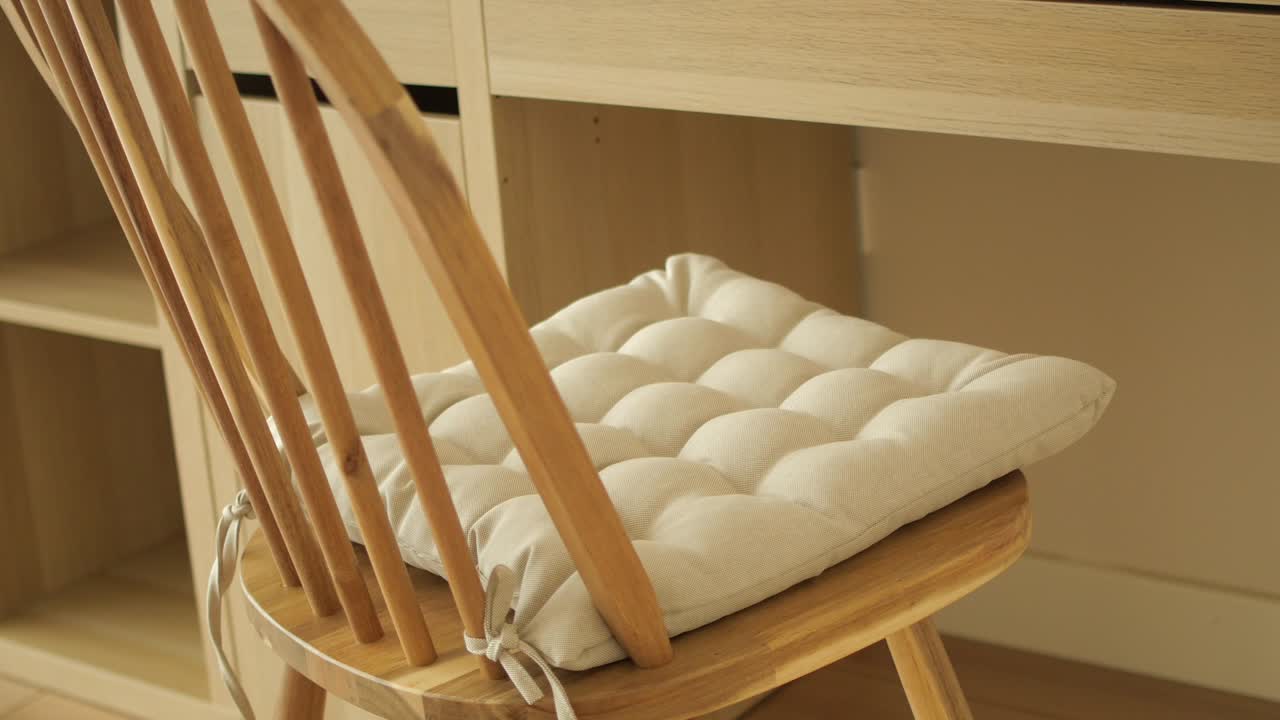 Wooden Chair with Beige Cushion at a Light Wood Desk