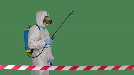 man worker in a protective uniform and a respirator with a high pressure apparatus walks and disinfects the infected area. isolated on a green screen chroma key. slow motion. close up