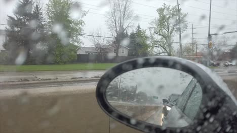 looking in side mirror on a rainy day while driving