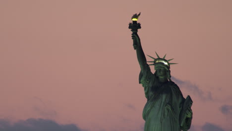 close-up of illuminated statue of liberty and pink sky