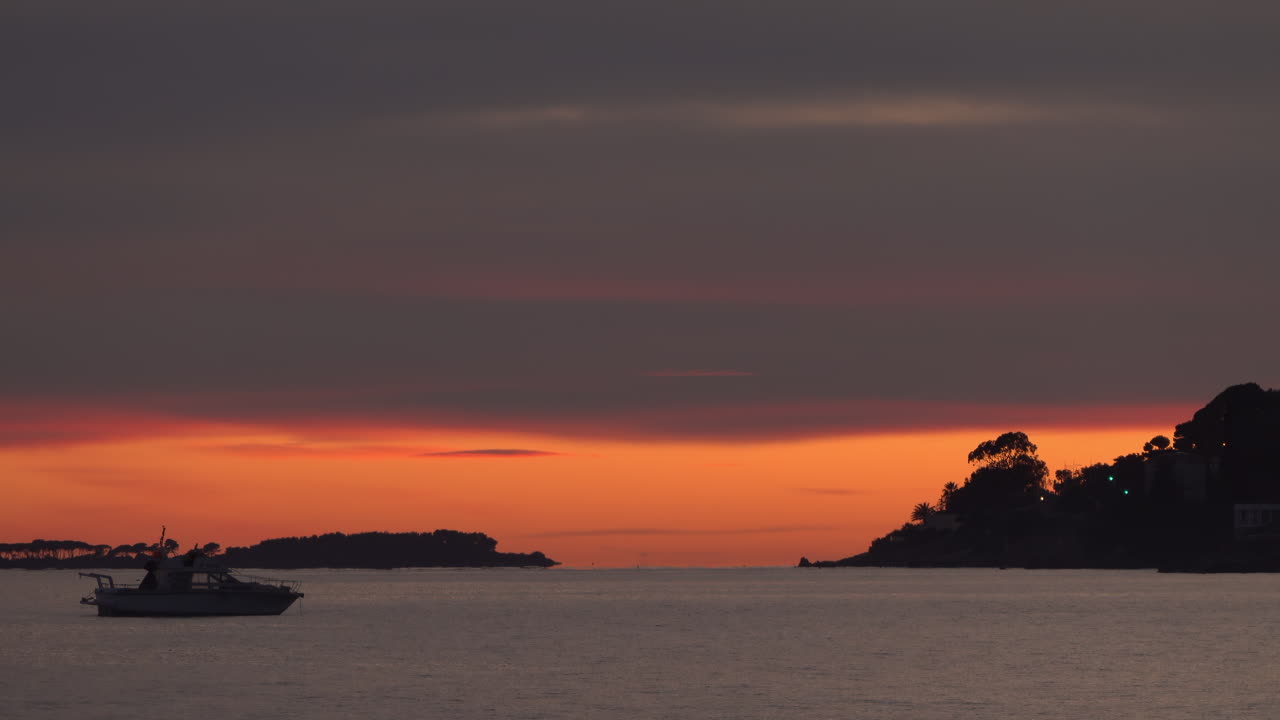View of a boat floating alone on the sea at sunset