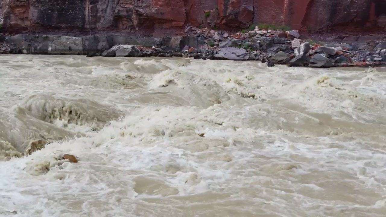Regione delle rapide di Warm Springs sul fiume Yampa, rapide impetuose del fiume creano acqua spumeggiante sotto scogliere di canyon aspre, panoramica lenta dettagliata verso destra