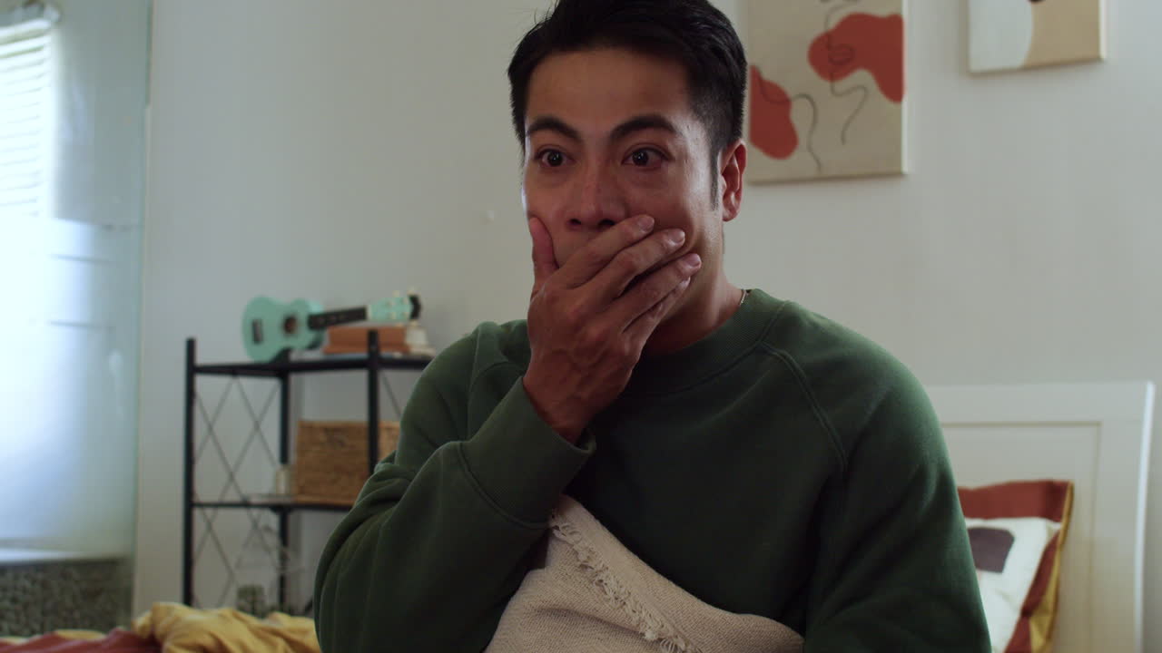 쇼크를 당한 남자가 tv를 보고 있다.