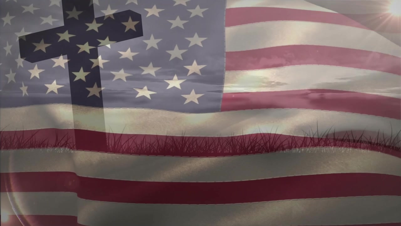Efter at en korssilhuet dukker op, blafrer et gennemsigtigt flag over græslinjen og oplyser daggryhimlen.