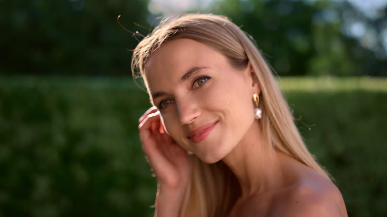 Donna attraente che guarda la macchina fotografica. Giovane donna che si tocca i capelli con la mano