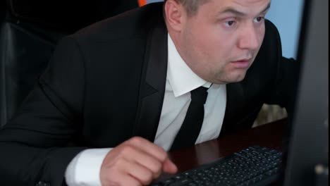 man in suit looking at computer