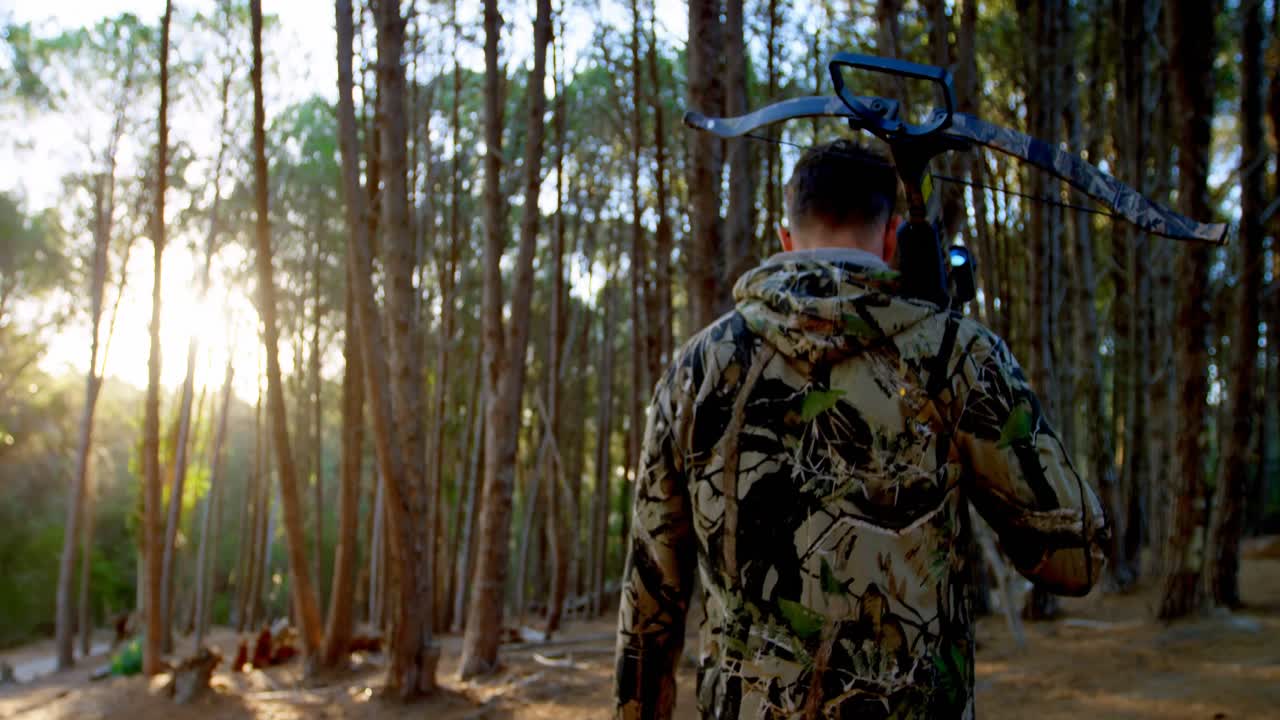 Uomo che cammina con arco e freccia nel bosco 4k