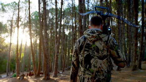 hombre caminando con arco y flecha en el bosque 4k