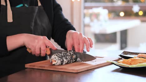 making sushi at home kitchen. woman hands rolling homemade sushi.