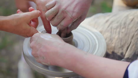 the master potter teaches the child how to make pots concept - transfer of experience training 4k sl