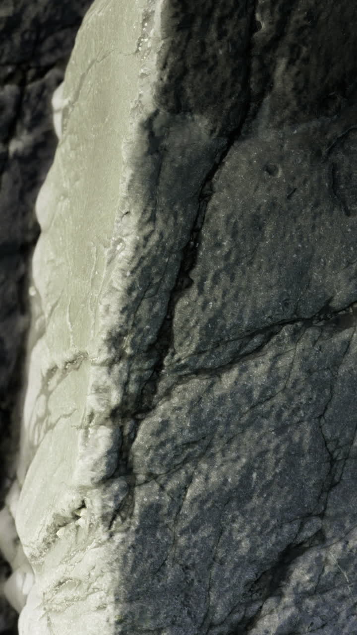 Nærbillede af tekstureret stenoverflade, der viser sprækker og detaljer