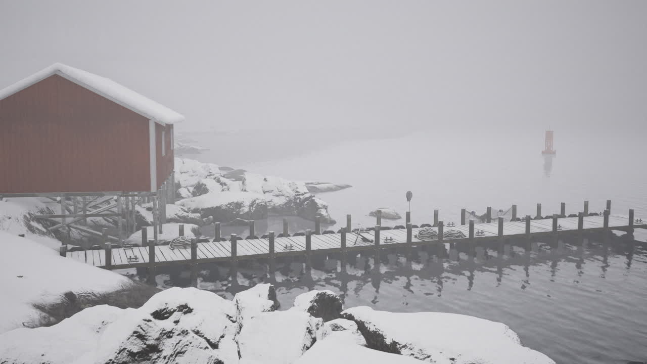 Winter landscape featuring a foggy dock and a red cabin by the water