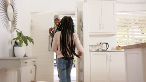happy african american male soldier embracing his daughter at home, slow motion