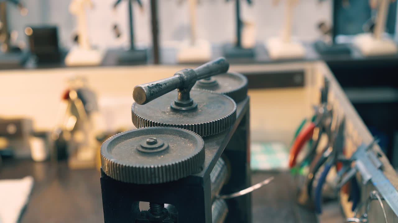 goldsmith turns lever on machine forge-rolling white metal