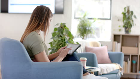 Caucasian-casual-businesswoman-using-tablet-in-office,-slow-motion