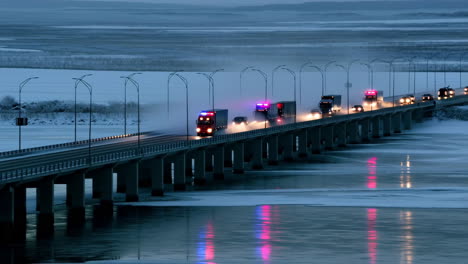 trucks crossing a bridge at night in winter