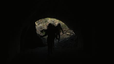 three women running through a dark tunnel