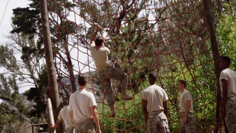 military troops climbing a net during obstacle course 4k