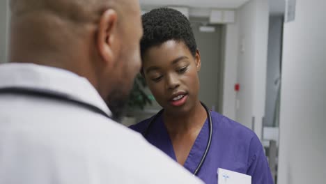 Médicos-Afroamericanos,-Hombres-Y-Mujeres,-Hablando-En-El-Hospital