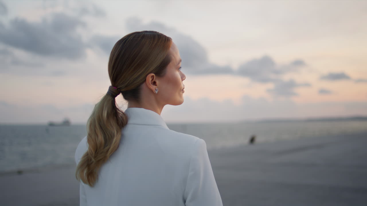 una mujer hermosa disfruta de la belleza de la noche caminando sola en un terraplén nublado de cerca.