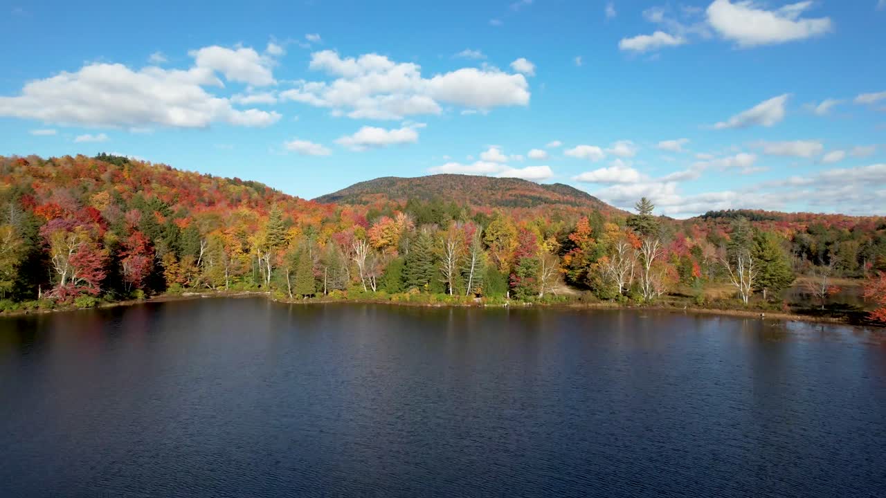 vista aérea del lago adirondack con cielo azul claro y hojas cambiantes de otoño