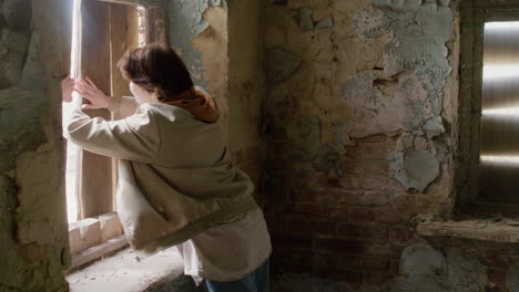 chica pelirroja tratando de escapar por la ventana de un edificio en ruinas durante una grabación 1