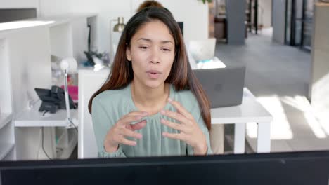 biracial casual businesswoman having laptop video call talking in office, slow motion