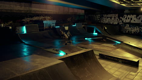 Teenage-athletes-performing-stunt-together-at-skate-park-with-graffiti-wall.