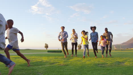 Dos-Familias-Jugando-Al-Fútbol-En-El-Parque