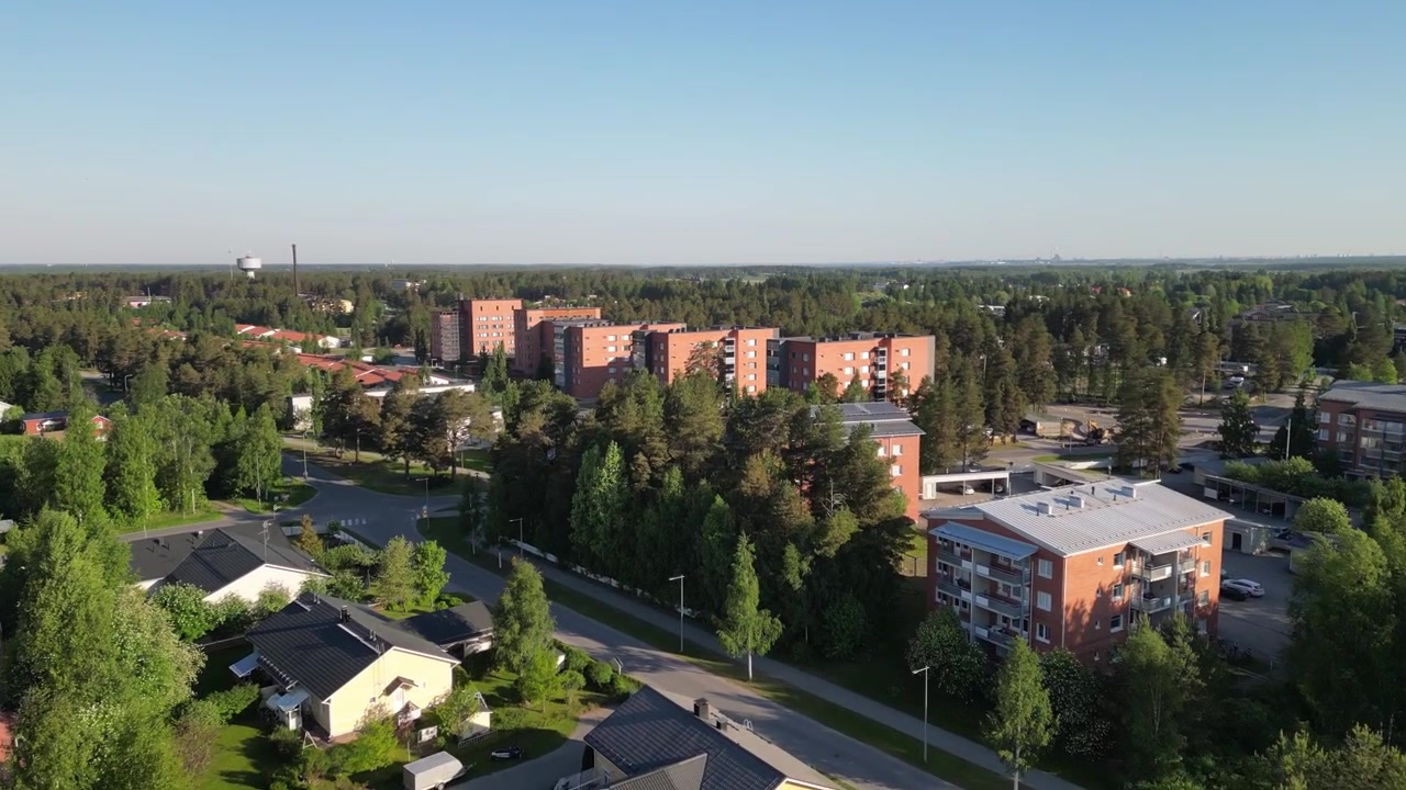 Letecký pohled na centrum města Kempele ve Finsku, s místní architekturou, ulicemi a zelenými městskými plochami pod jasným letním sluncem