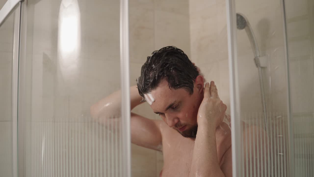 hombre lavando el cabello en la ducha